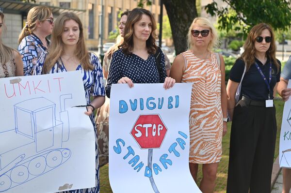 На фото: участница акции протеста держит плакат с надписью: "Двойные стандарты". На фото: участница акции протеста держит плакат с надписью: "Двойные стандарты". - Sputnik Литва