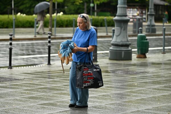 На фото: женщина на улице Вильнюса после проливного дождя. - Sputnik Литва