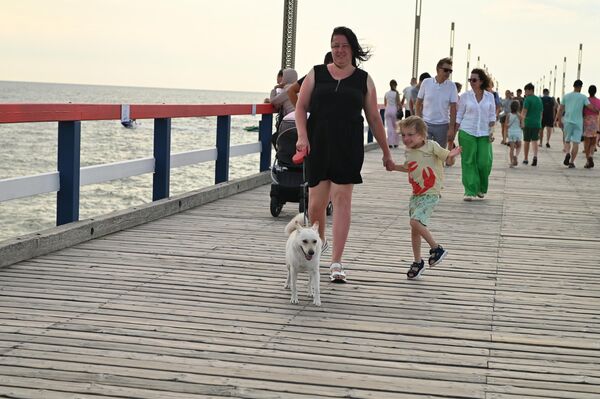 На фото: люди прогуливаются по пирсу в Паланге. - Sputnik Литва