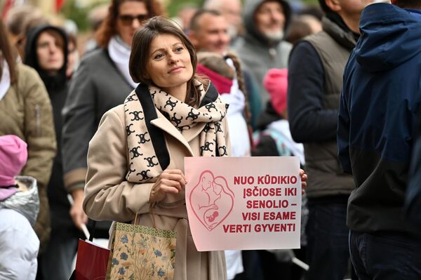 На фото: участница марша держит плакат с надписью: &quot;От младенца в утробе до старика — все достойны жить&quot;. - Sputnik Литва