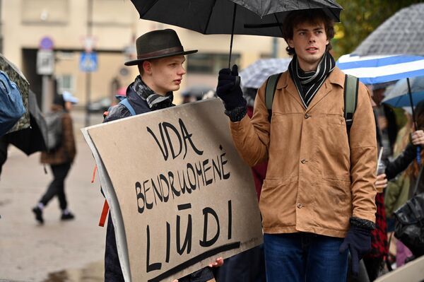 На фото: участница протеста с плакатом &quot;Сообщество VDA скорбит&quot;.  - Sputnik Литва