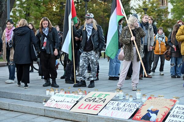 Участники акции солидарности с народом Палестины принесли флаги и плакаты, зажгли траурные свечи по погибшим. - Sputnik Литва