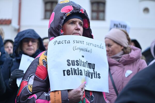 На фото: участница акции протеста держит плакат с надписью: &quot;Договоры должны соблюдаться&quot;. - Sputnik Литва
