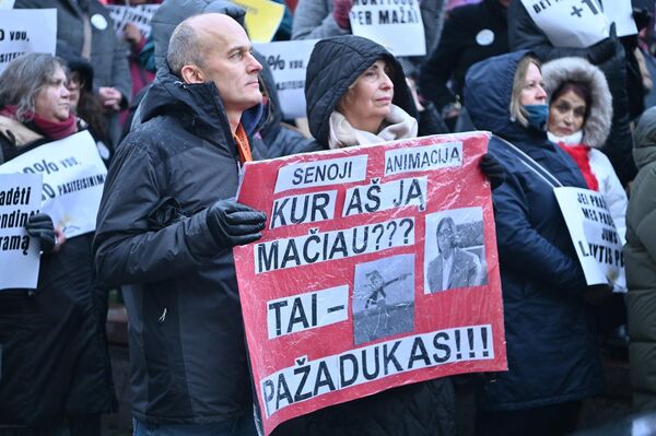 На фото: участники акции протеста держат плакат с надписью: &quot;Старая анимация. Где я ее видел? Это — обещание… [на фото изображены Пинокио и Раминта Поповене]&quot;. - Sputnik Литва