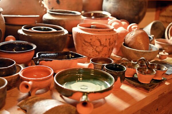 Посетители мастерской могут слушать рассказы мастеров, попивая кофе из реконструированных чашек, а могут даже попробовать сами вдохнуть жизнь в глину. - Sputnik Литва