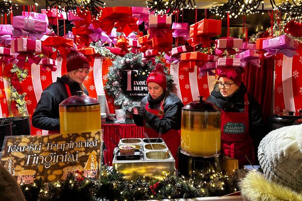 Рядом с елкой расположился Рождественский городок — деревянные домики, где продают традиционные литовские изделия, лакомства и уникальные подарки от местных мастеров. - Sputnik Литва