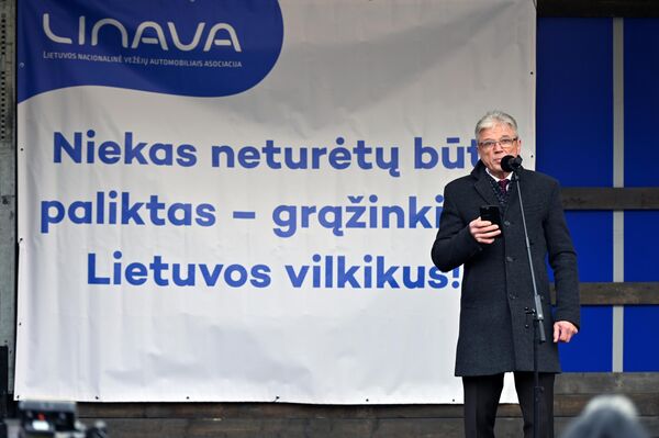 На фото: президент Linava Эрландас Микенас на митинге с надписью &quot;Никто не должен быть оставленным - верните литовские тягачи&quot; на заднем фоне. - Sputnik Литва