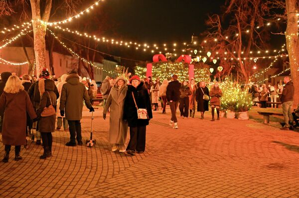 Утром возле дверей Музея денег Банка Литвы всех собравшихся встретили рождественские песни в исполнении хора. Именно здесь символически на один день в столице была введена рождественская валюта, ставшая игривым акцентом инициативы — красные сосновые шишки. - Sputnik Литва