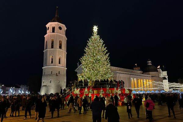 Вечером Ратушная площадь превратилась в огромную сцену — рядом с рождественским катком, а также на самом льду собрались хористы, музыканты и горожане, которые вместе исполнили песню "Счастливого Рождества". - Sputnik Литва