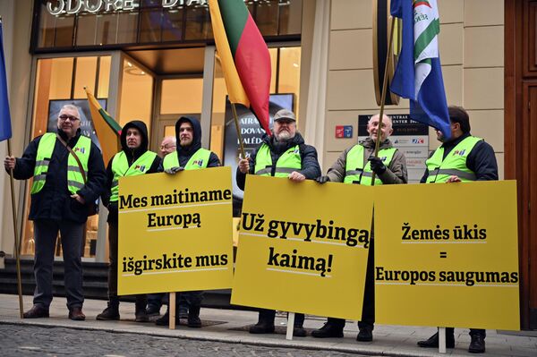 На фото: участники акции протеста держат плакаты с надписями: "Мы кормим Европу, услышьте нас", "За жизнеспособную деревню", "Сельское хозяйство = безопасность Европы". - Sputnik Литва