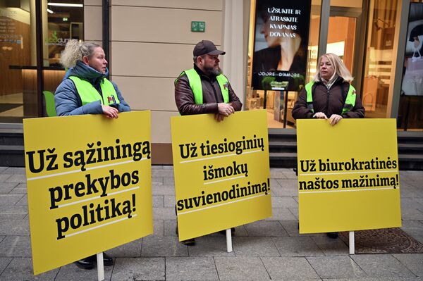 На фото: участники акции протеста держат плакаты с надписями: "За честную торговую политику", "За уравнение прямых выплат", "За снижение бюрократического бремени". - Sputnik Литва