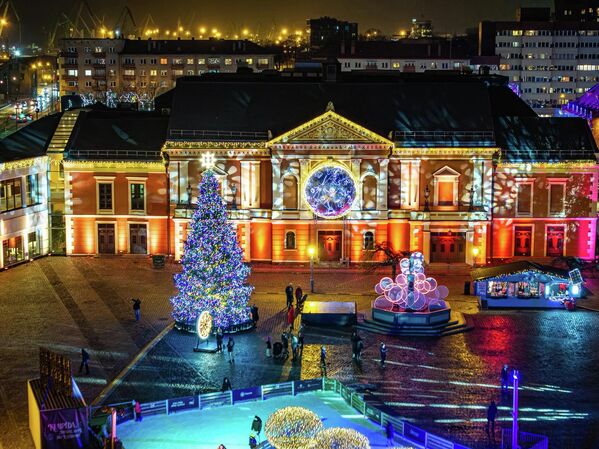 Вот уже десятый год подряд в Клайпеде продолжается традиция дарить городу рождественскую елку. Каждый год, за несколько месяцев до Рождества, объявляется конкурс на место главной городской елки. В этом году конкурс победила 12-метровая ель. Ее украсили тысячами разноцветных огней, а на самой вершине установили звезду. - Sputnik Литва