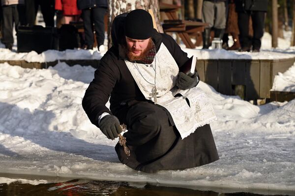 На фото: отец Михаил освящает воду перед купанием верующих. - Sputnik Литва