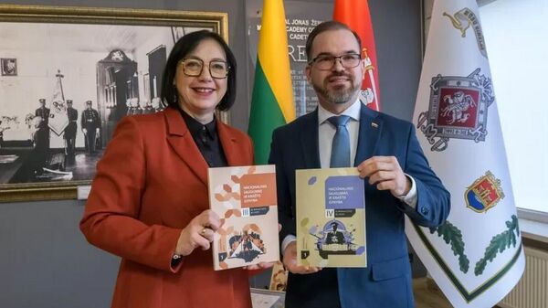 Глава МО Литвы Робертас Каунас и министр образования Литвы Раминта Поповене с учебником по национальной безопасности и обороне  - Sputnik Литва