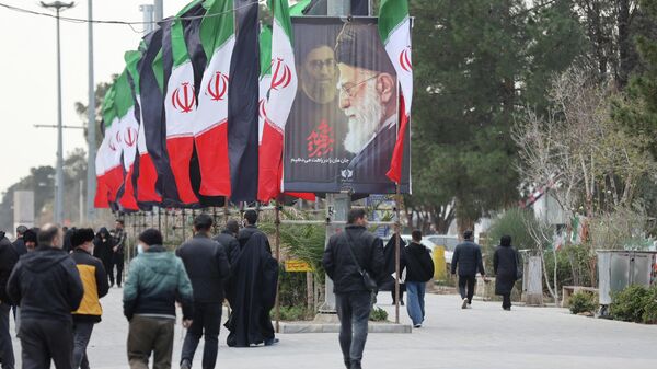 Флаги Ирана и изображение погибшего верховного лидера Ирана Али Хаменеи в Тегеране - Sputnik Литва