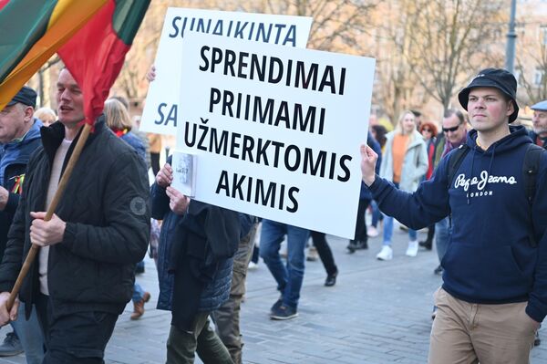 На фото: участники акции протеста несут плакат с надписью: "Решения принимаются с закрытыми глазами". - Sputnik Литва