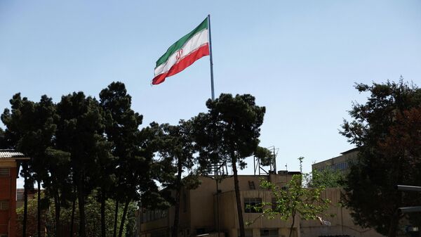 Флаг Ирана около атакованного Технологического университета имени Шарифа в Тегеране - Sputnik Литва