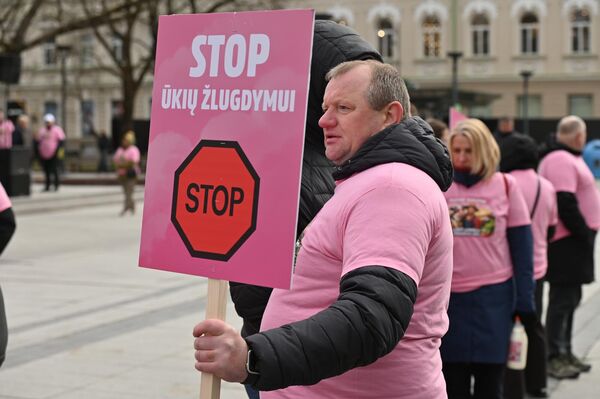 На фото: участник акции протеста держит плакат с надписью: "Стоп уничтожению сельского хозяйства". - Sputnik Литва