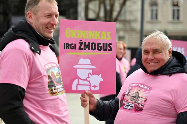 На фото: участник акции протеста держит плакат с надписью: "Фермер тоже человек". - Sputnik Литва