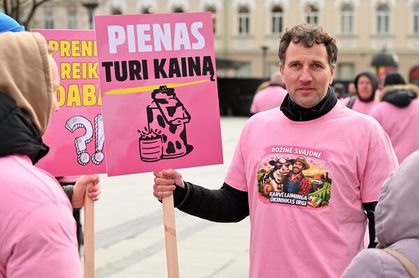 На фото: участник акции протеста держит плакат с надписью: "У молока есть цена". - Sputnik Литва