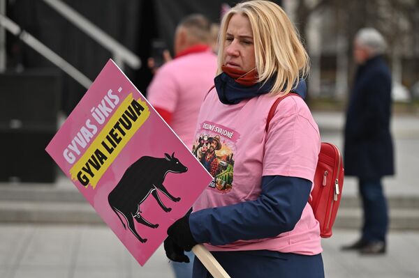 На фото: участница акции протеста держит плакат с надписью: "Живое сельское хозяйство — жива Литва". - Sputnik Литва