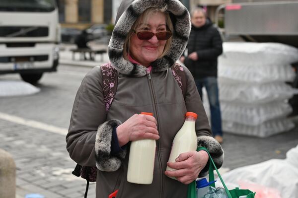 На фото: жительница Вильнюса с бесплатным молоком.  - Sputnik Литва