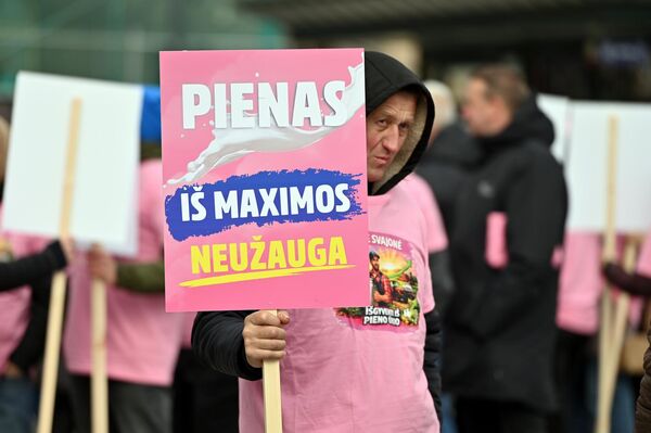 На фото: участник акции протеста держит плакат с надписью: "Молоко не растет в Maxima". - Sputnik Литва