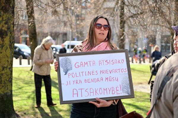 На фото: участница протеста с плакатом "Природа отвергает политическое принуждение — она наша общая собственность". - Sputnik Литва