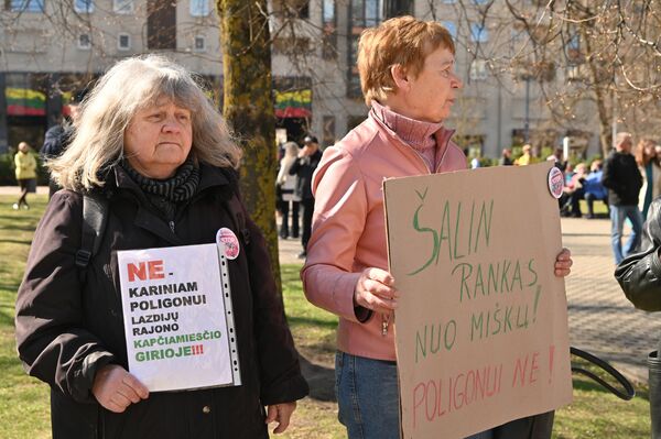 На фото: участницы протеста с плакатами: "НЕТ военному полигону в Капчяместисском лесу Лаздияйского района" и "Руки прочь от лесов! Нет полигону!" - Sputnik Литва