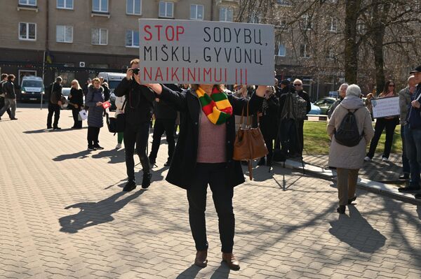 На фото: участница протеста с плакатом "СТОП уничтожению домовладений, лесов и животных!" - Sputnik Литва