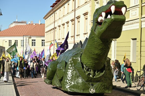 "Провинившегося" динозавра сопровождают к зданию филфака на разных транспортных средствах. - Sputnik Литва