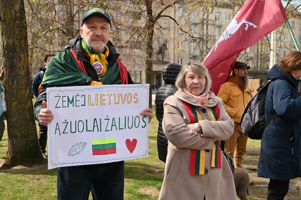 На фото: участник акции протеста держит плакат со словами из песни про любовь к родной Литве: "На литовской земле дубы будут зеленеть". - Sputnik Литва