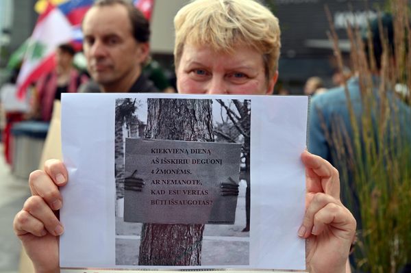 На фото: участница акции протеста держит фото дерева с прикрепленной к нему табличкой: "Каждый день я выделяю кислород для четырех человек. Не считаете, что я должен быть сохранен?" - Sputnik Литва