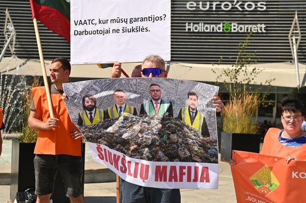 На фото: участник пикета держит плакат, на котором изображены представители власти, и имеется подпись: "Мусорная мафия". - Sputnik Литва