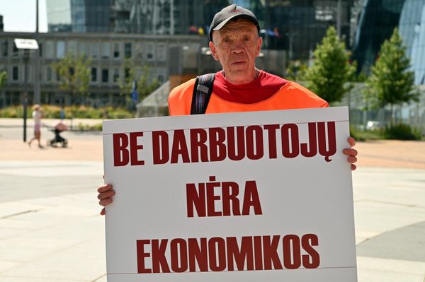 На фото: участник пикета держит плакат с надписью: "Без работников нет экономики". - Sputnik Литва