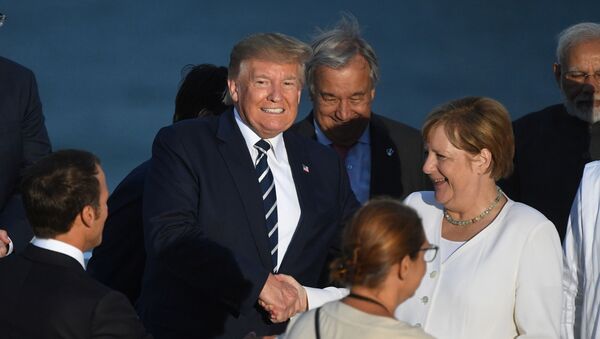 Президент Франции Эммануэль Макрон, президент США Дональд Трамп и канцлер Германии Ангела Меркель пожимают друг другу руки на саммите G7 в Биаррице, Франция, 25 августа 2019 года - Sputnik Литва