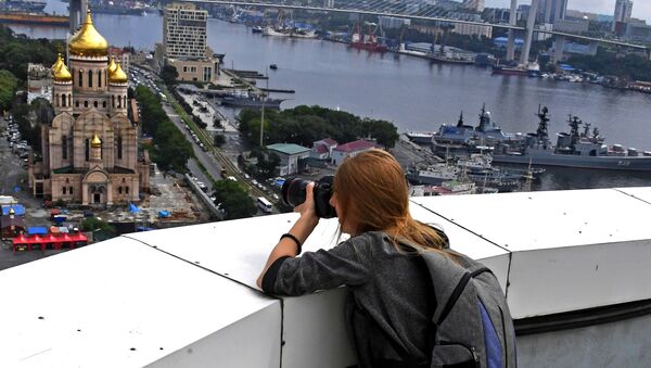 Девушка фотографирует с крыши высотного здания администрации Приморского края во Владивостоке - Sputnik Литва