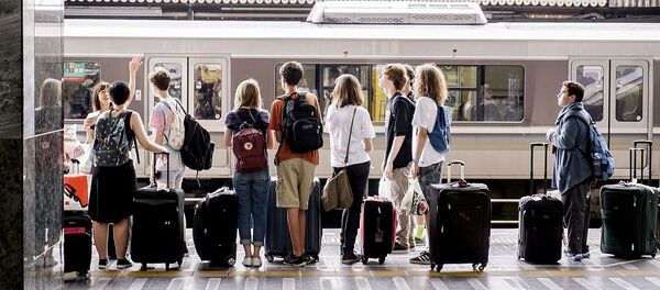 Молодые люди на станции железнодорожного вокзала, архивное фото Молодые люди на станции железнодорожного вокзала, архивное фото - Sputnik Lietuva