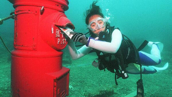 Водолаз кладет пластиковое письмо в почтовый ящик, установленный на глубине 10 метров на дне моря у берегов Сузами в префектуре Вакаяма - Sputnik Литва