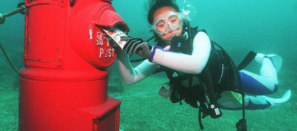 Водолаз кладет пластиковое письмо в почтовый ящик, установленный на глубине 10 метров на дне моря у берегов Сузами в префектуре Вакаяма Водолаз кладет пластиковое письмо в почтовый ящик, установленный на глубине 10 метров на дне моря у берегов Сузами в префектуре Вакаяма - Sputnik Lietuva