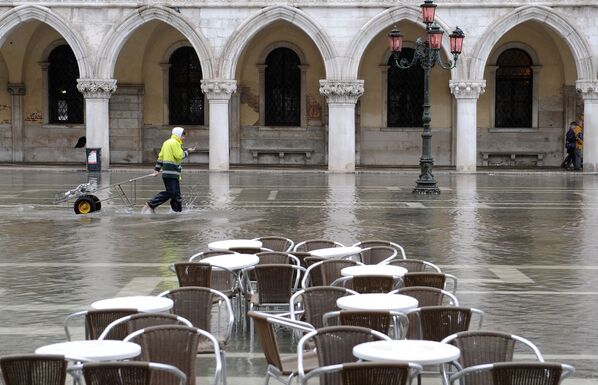 Итальянский почтальон пересекает затопленную площадь Сан-Марко в Венеции - Sputnik Литва
