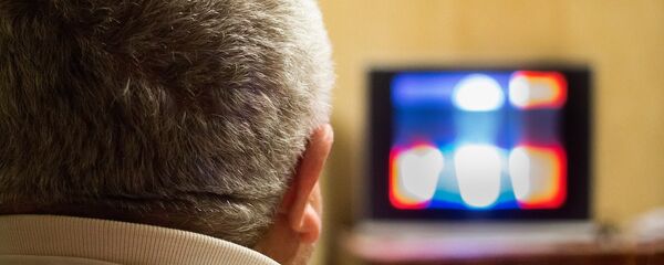 Мужчина смотрит телевизор, архивное фото - Sputnik Литва