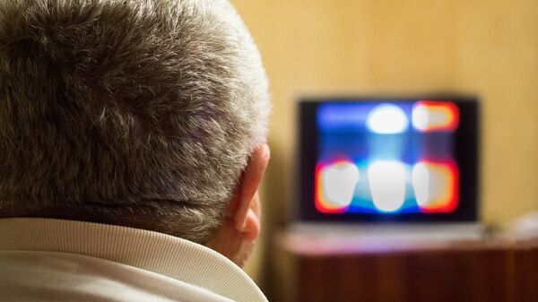 Мужчина смотрит телевизор, архивное фото - Sputnik Литва