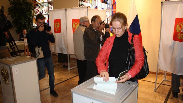 Гражданка России опускает бюллетень в урну для голосования, архивное фото - Sputnik Литва