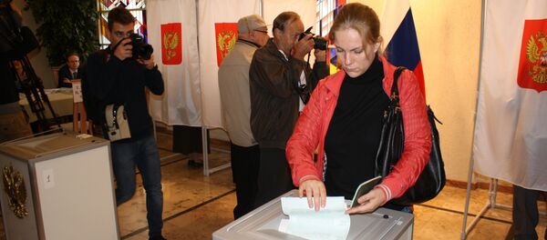 Гражданка России опускает бюллетень в урну для голосования, архивное фото Гражданка России опускает бюллетень в урну для голосования, архивное фото - Sputnik Литва