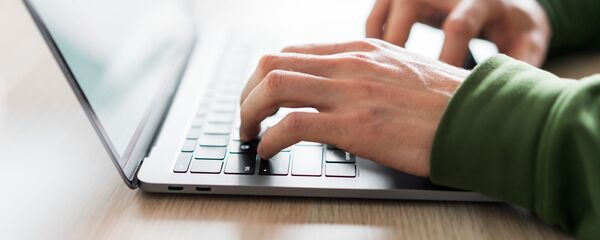 Мужчина работает за ноутбуком, архивное фото - Sputnik Литва