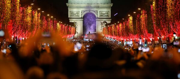 Зрители во время праздничного светового шоу перед Триумфальной аркой в Париже - Sputnik Lietuva