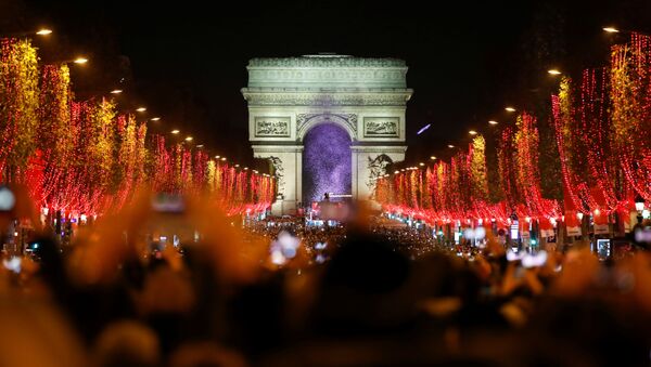 Зрители во время праздничного светового шоу перед Триумфальной аркой в Париже - Sputnik Lietuva