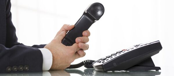 Человек держит трубку стационарного телефона - Sputnik Литва