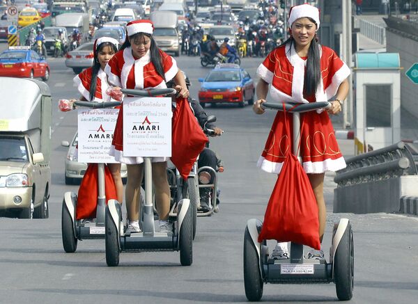 Работницы отеля в костюмах Санта-Клауса во время раздачи подарков в Бангкоке  - Sputnik Lietuva